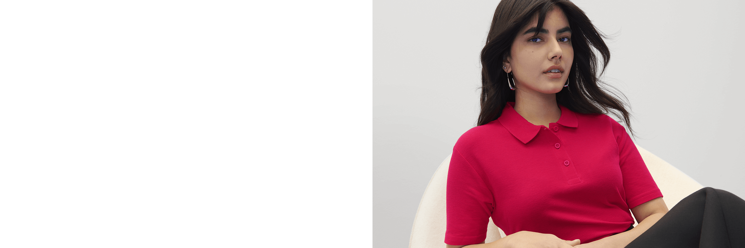 Woman wearing a red polo shirt sitting on a white chair against a light gray background